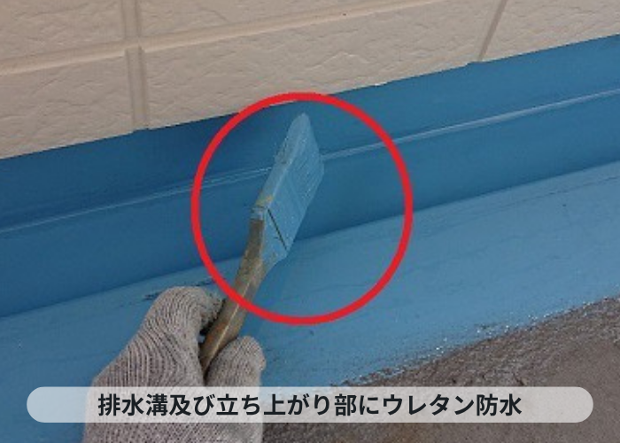 加西市　共用廊下の排水溝にウレタン防水を塗っている様子