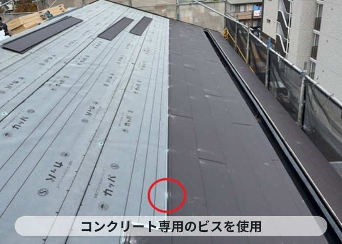 尼崎市　屋根重ね葺き工事で新しい屋根材をコンクリートビスで固定している様子