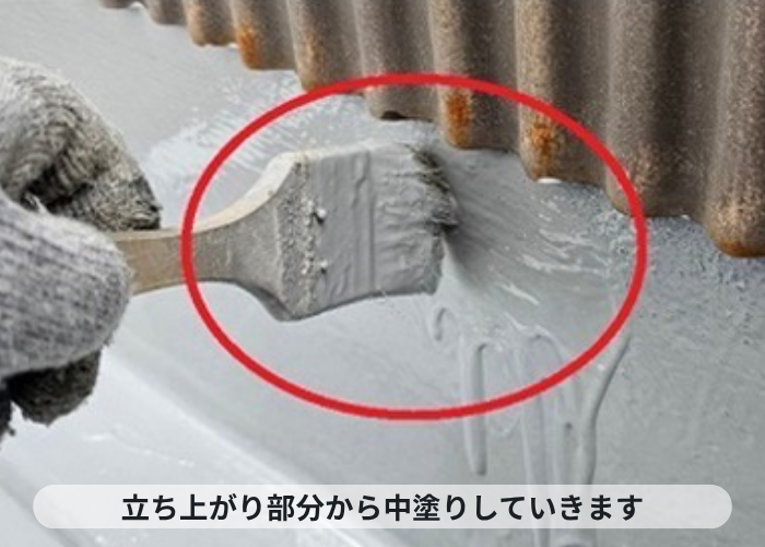 伊丹市2階建てアパートのバルコニーの立ち上がり部分からウレタン防水を中塗りしている様子