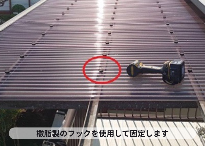 宝塚市　２階ベランダ屋根のポリカ波板をフックで固定している様子
