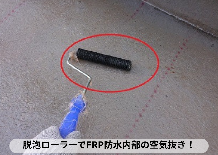 東灘区　FRP防水工事で脱泡ローラーを使用し空気を抜いている様子