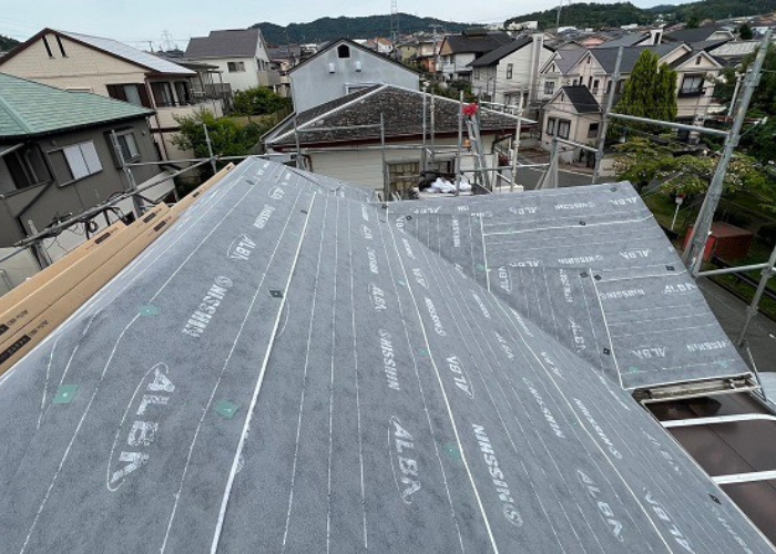 三木市　スレート屋根へのカバー工事で防水シートを貼っている様子