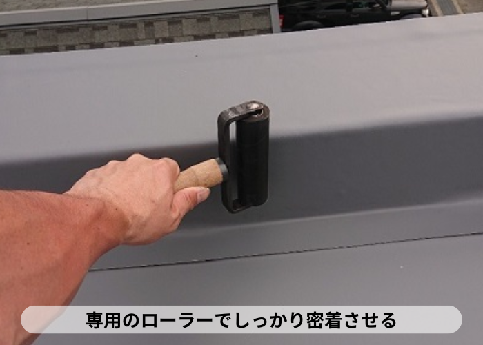 西宮市　屋上防水工事で立ち上がり部分に密着工法している様子