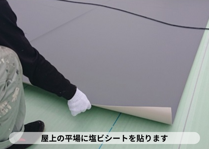 西宮市　屋上の平場に塩ビシート防水を貼っている様子