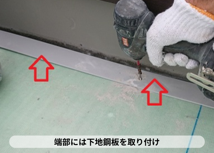 西宮市　屋上の端部に鋼板を取り付けている様子