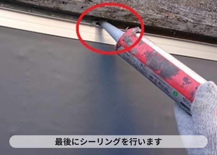 尼崎市　陸屋根防水工事で仕上げのシーリングを行ている様子